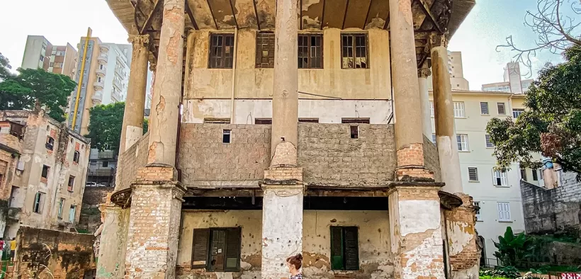 Mulher andando em frente a construção que faz parte da Vila Itororó, espaço cultural em São Paulo.